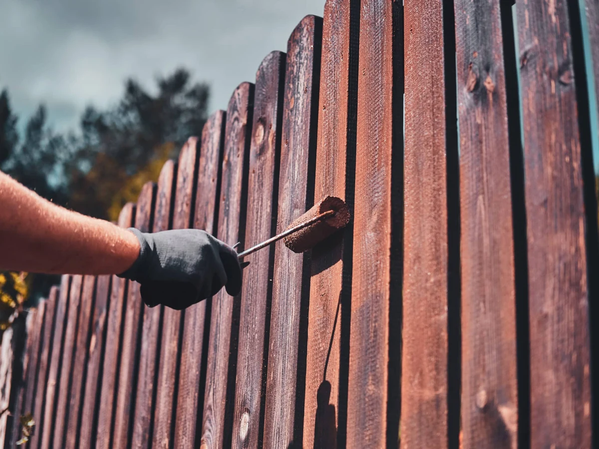 Painter applying finish to wooden fence panels in Sheffield
