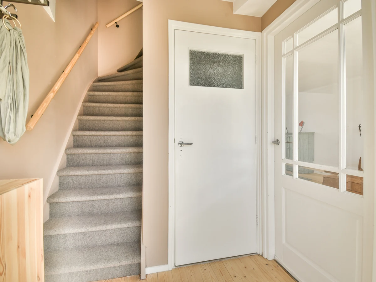 Staircase painting in Sheffield by Sheffield Decorators, bright hallway with carpeted stairs
